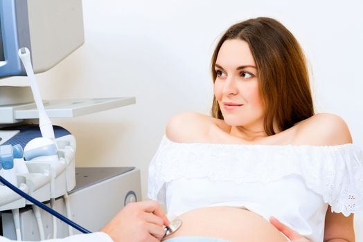 Young attractive pregnant woman on reception at the doctor, health check