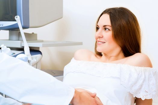 Young attractive pregnant woman on reception at the doctor, health check