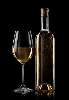 Bottle and glass of white wine on a black background