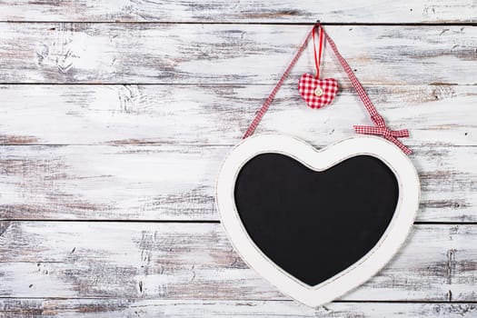 The heart shape chalkboard over shabby wooden background