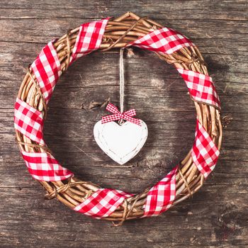 White heart and wreath over wooden old background