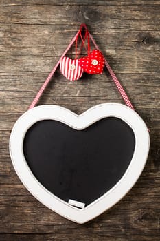 The heart shape chalkboard over old wooden background