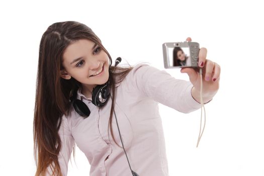 Cheerful schoolgirl taking her own pictures over white