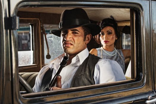 Sneering 1920s vintage gangsters inside automobile