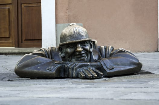 Cumil, emerging statue in the city of Bratislava, Slovakia.