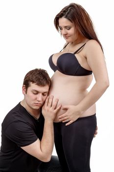 loving happy couple, pregnant woman with her husband, isolated on white background, husband listening baby