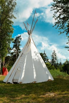 A tipi (also tepee and teepee) is a conical tent, traditionally made of animal skins, and wooden poles against blue sky
