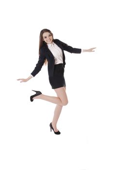 Joyful student girl in uniform dancing over white