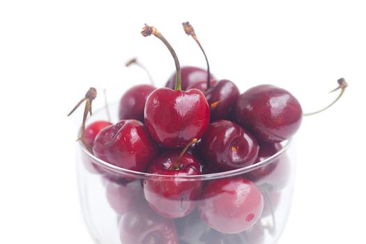 Cherries in a glass bowl isolated on white