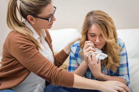 Mother soothes sad teen daughter crying by problems