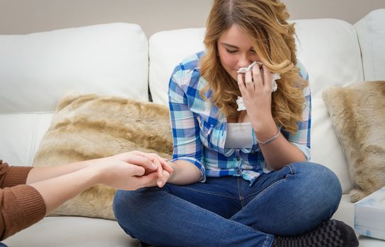 Hands of mother closeup consoling sad teen daughter crying by problems