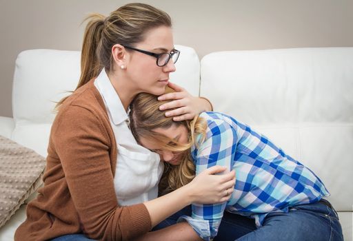 Mother embracing and soothes depressed teen daughter by problems