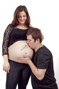 loving happy couple, pregnant woman with her husband, isolated on white background, husband kissing tummy