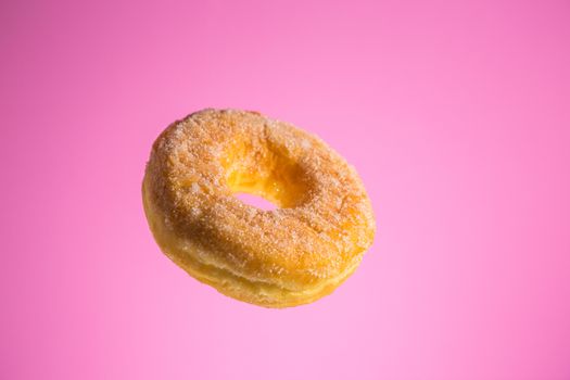 Sugar coated donut, studio shot on light pink background 