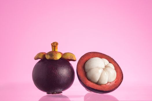 Tropical mangosteen fruits, queen of fruits, studio shot on pink background 