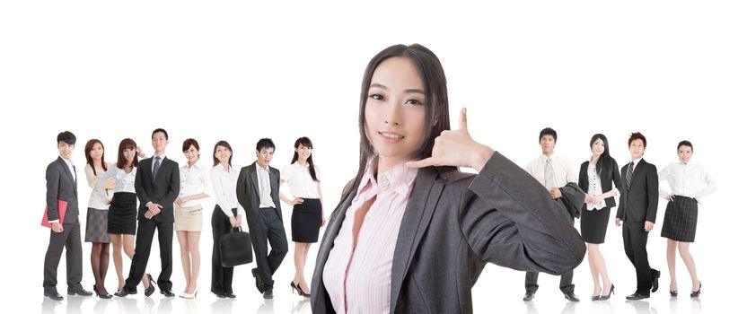 Attractive Asian business woman give you a phone call sign and stand in front of her team.