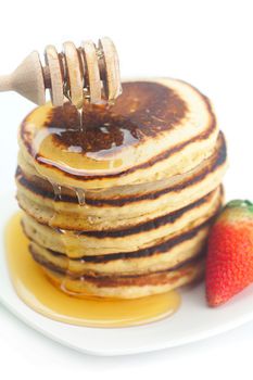 Pancakes, honey, strawberry and stick to honey isolated on white