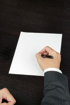 Close-up of a businessman writing, shot from above.
