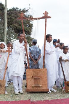 Clergyman stands next to a big Begena, a traditional Ethiopian string instrument with ten strings belonging to the family of the lyre, during Timket celebrations of Epiphany, on January 18, 2014 in Addis Ababa.