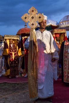 A priest carrying a large cross in front of his fellow clergymen carrying Tabots, a model of the Arc of Covenant, during a colorful procession of Timket celebrations of Epiphany, commemorating the baptism of Jesus, on January 18, 2014 in Addis Ababa.