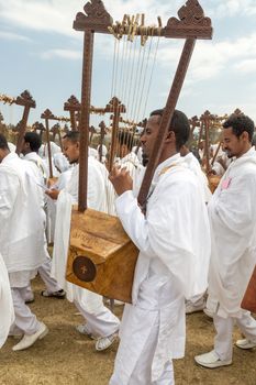 Clergy playing the Begena, a traditional string based instrument, while accompanying the Tabot, a model of the arc of covenant, during a colorful procession which is part of Timket celebrations of Epiphany, on January 19, 2014 in Addis Ababa.