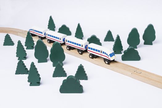 fast train driving through small forest. scenery made of wooden toy
