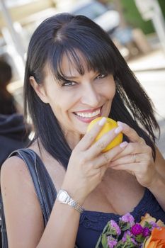 Pretty Italian Woman Smelling Fresh Oranges at the Street Market.