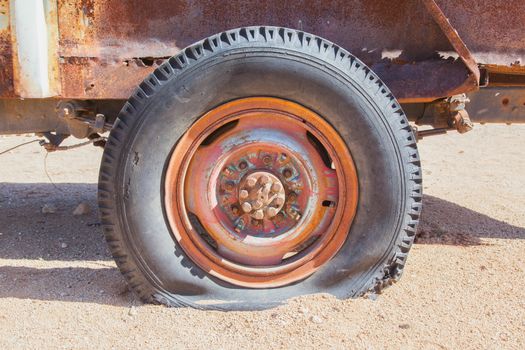 Detail of a vintage abandoned flat car tire on the side of a road, Namibia