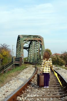 little girl walking on railroad