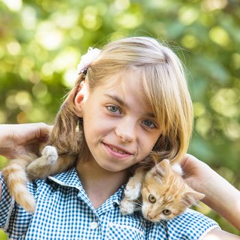 Girl play with kitten outdoor in the park