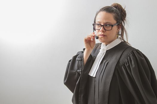 thirty something brunette woman wearing a canadian lawyer toga with a telephone headset on her head