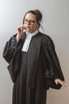 thirty something brunette woman wearing a canadian lawyer toga, talking with a telephone headset on her head