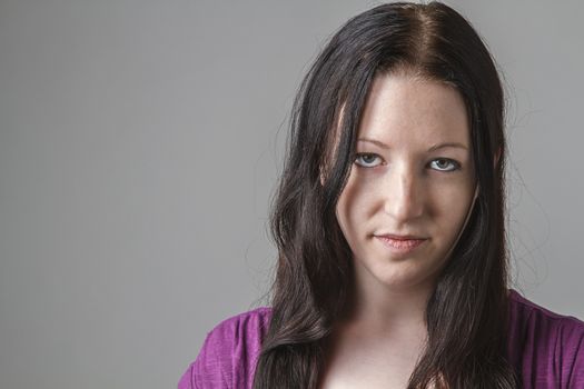 young woman with long black hair and an angry expression