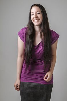 young woman with long black hair and a purple shirt, in the middle of cracking up laughing