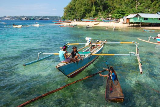 Children plays at boats near village coast, Indonesia