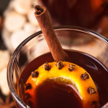 A mulled wine in the glass cup on wooden background