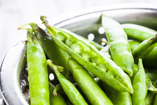 Green pea in the colander, close up