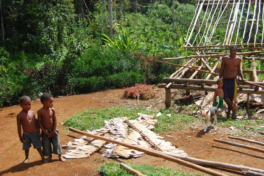 Kids and man near house at village, Kokoda Track, Papua New Guinea