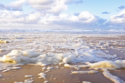 Ocean foam at the beach on a stormy day