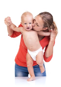 Baby boy learning to walk with mother's help over white