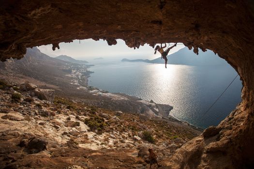 Family rock climber against picturesque view of Telendos Island at sunset. Kalymnos Island, Greece.