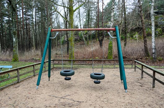 out toy swing located on playground in the woods