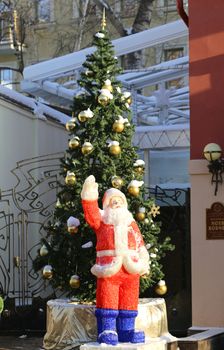 Santa Claus standing near a Christmas tree