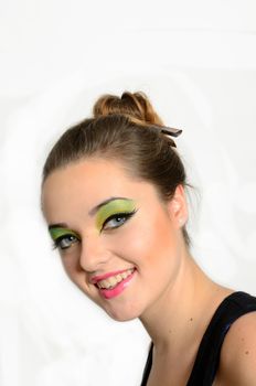 Teenage girl from Poland. Portrait of young female with hairs tighten up, colorful makeup, model smiling gently.
