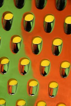 Macro view of a stainless steel cheese grater with reflected colors