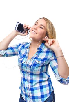 Portrait of beautiful blonde teenager listening music with a smartphone on white background