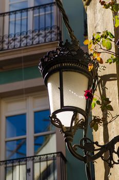 A classic cast iron street lamp attached to a facade