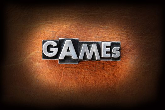 The word games made from vintage lead letterpress type on a leather background.