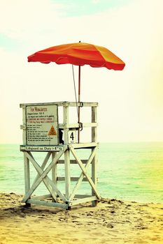 An empty lifeguard tower overlooking the ocean at the beach.
