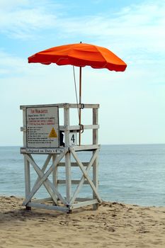 An empty lifeguard tower overlooking the ocean at the beach.